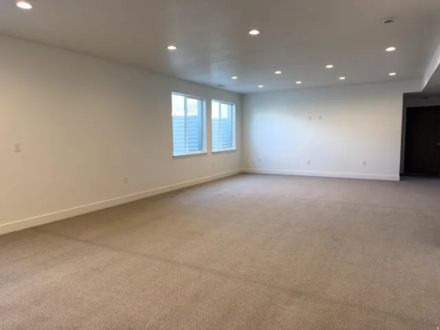 Empty room with recessed lighting and light colored carpet
