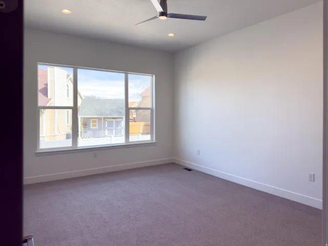 Spare room featuring a ceiling fan, dark colored carpet, and recessed lighting