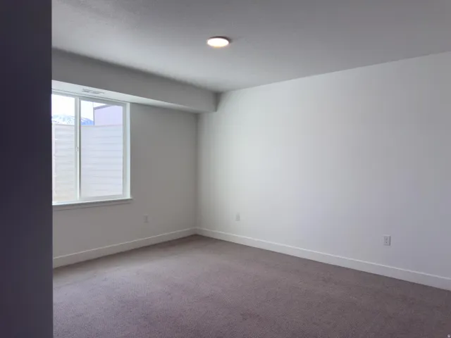Carpeted empty room with baseboards