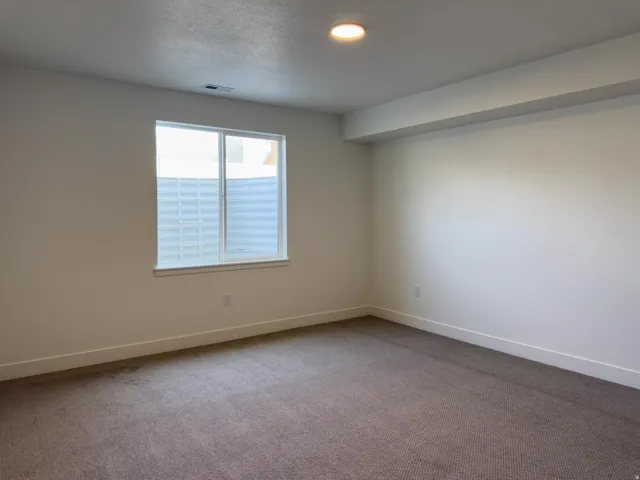Carpeted spare room featuring baseboards and a textured ceiling