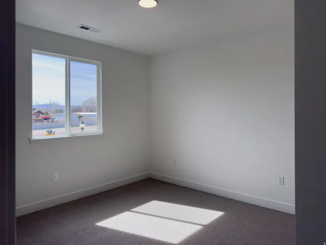 Carpeted empty room with baseboards