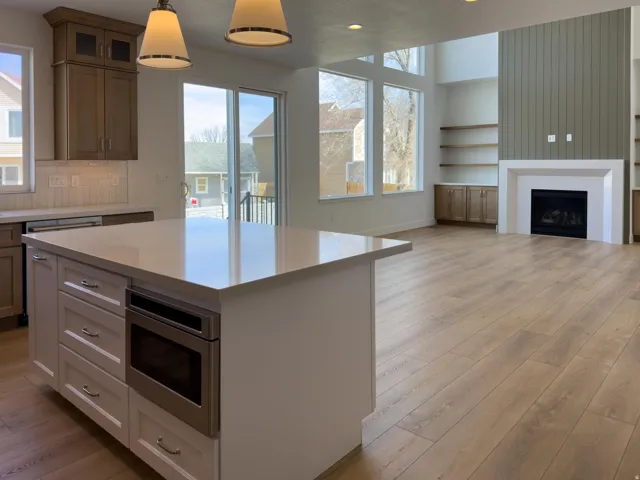 Kitchen featuring built in features, light wood-style flooring, glass insert cabinets, and healthy amount of natural light