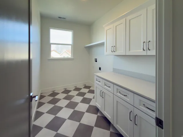 Laundry room with dark flooring, cabinet space, hookup for a washing machine, and electric dryer hookup