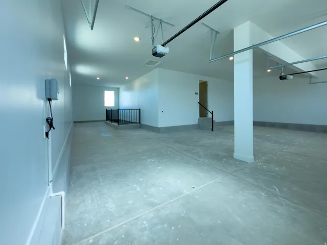 Garage finished with baseboards and recessed lighting, Entrance stairway to the basement