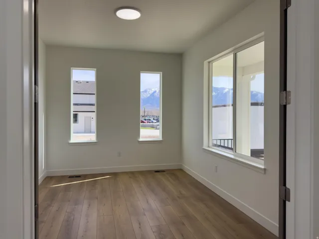 Empty room with dark wood-type flooring and a mountain view