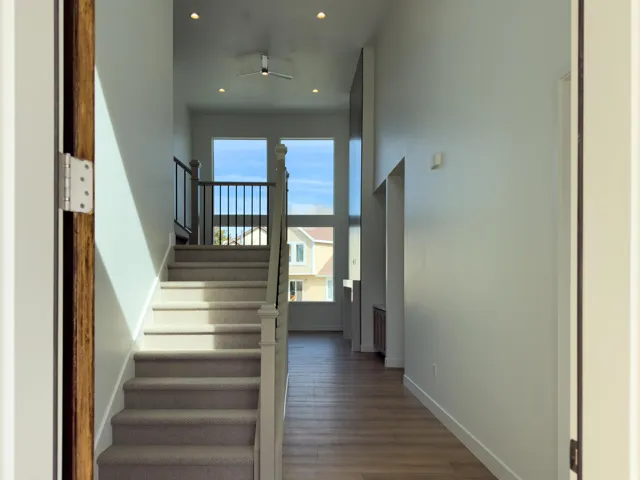Stairway with recessed lighting and wood finished floors