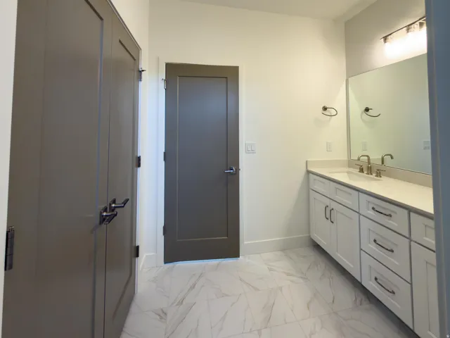 Bathroom with light marble finish flooring and vanity