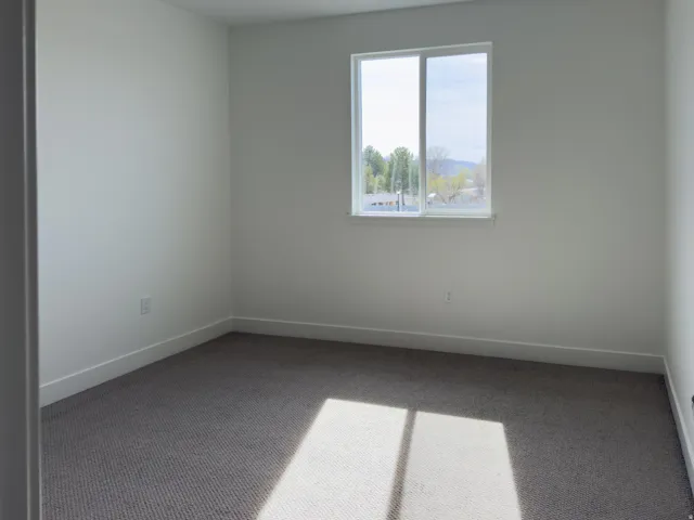 Empty room featuring carpet and baseboards