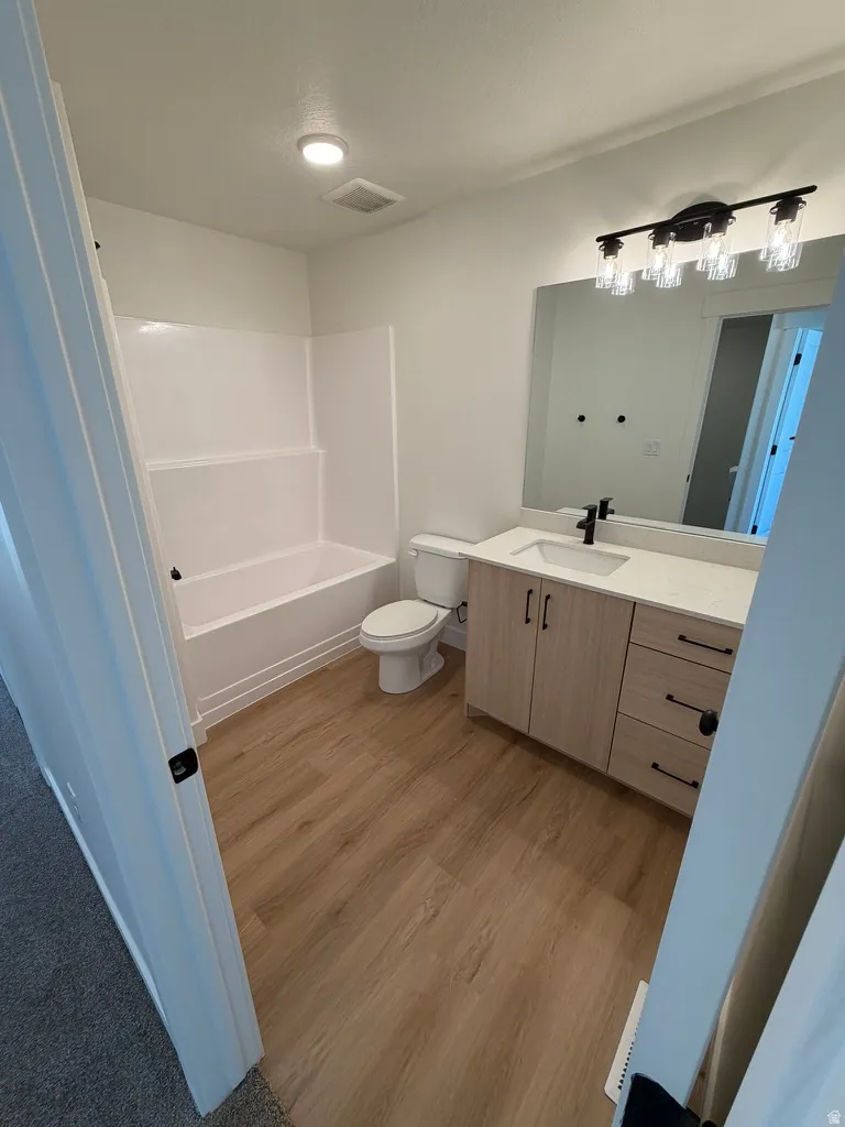 Bathroom with vanity, light wood-style flooring, and bathing tub / shower combination