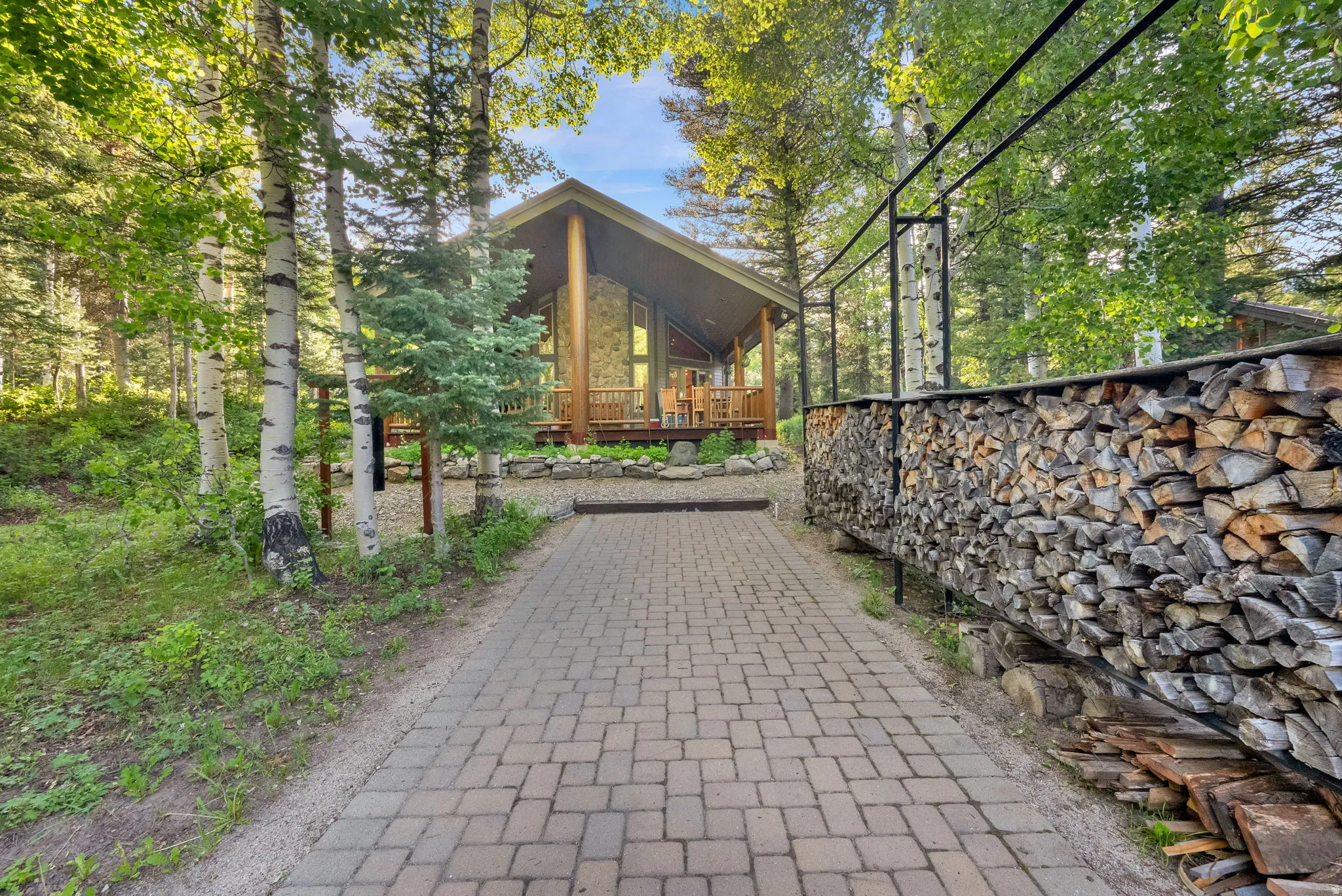 Cabin-style property featuring a pitched roof and a facade with expansive windows