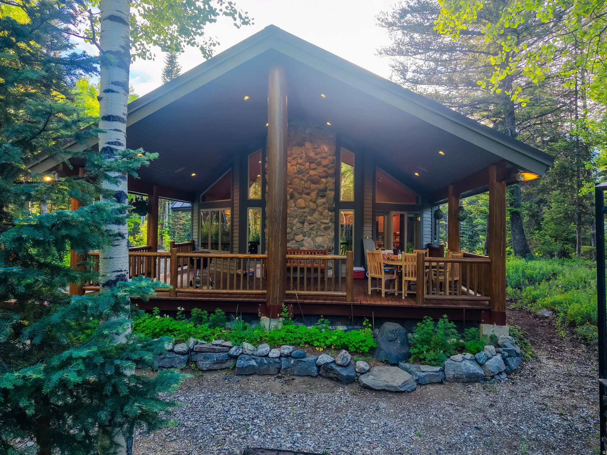 Covered deck featuring a natural wood railing system and recessed lighting