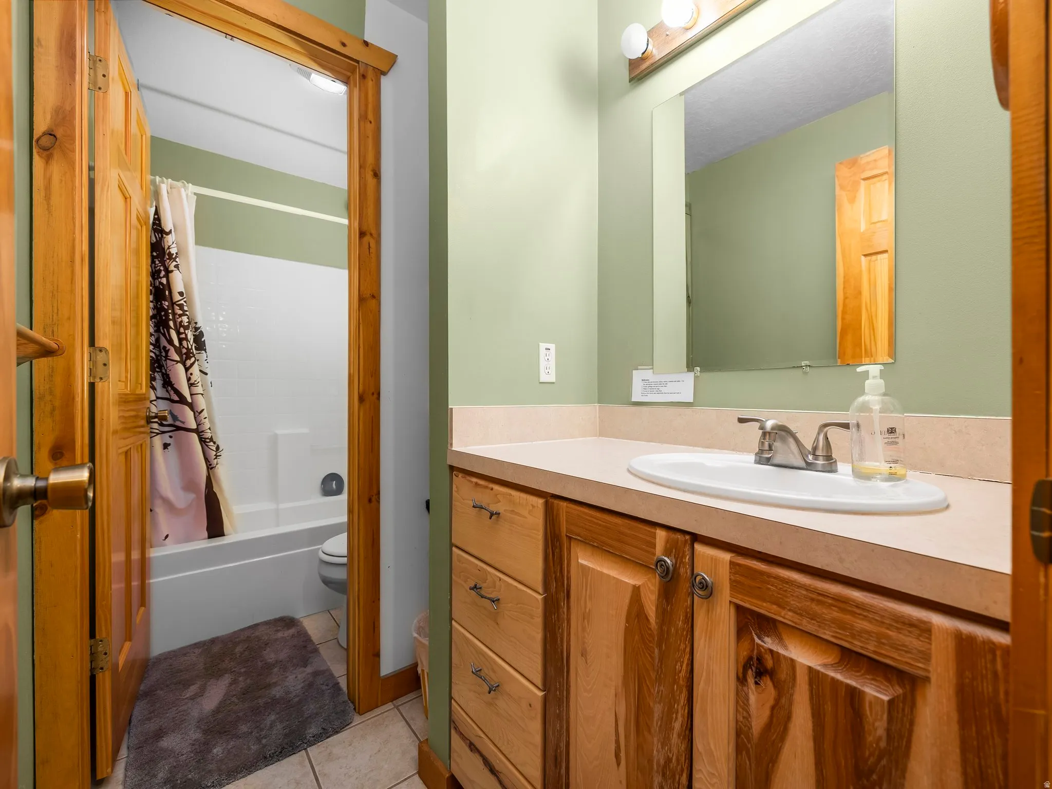 Bathroom with vanity, light tile patterned flooring, and shower / bath combo with shower curtain