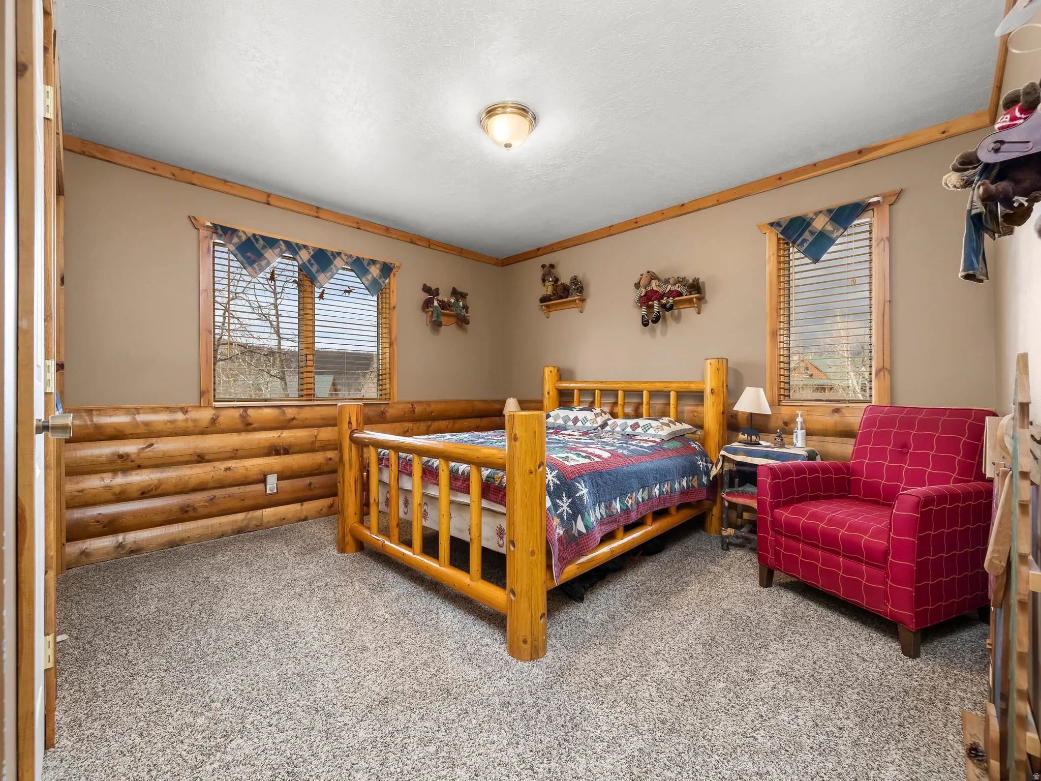 Bedroom with light carpet and log walls