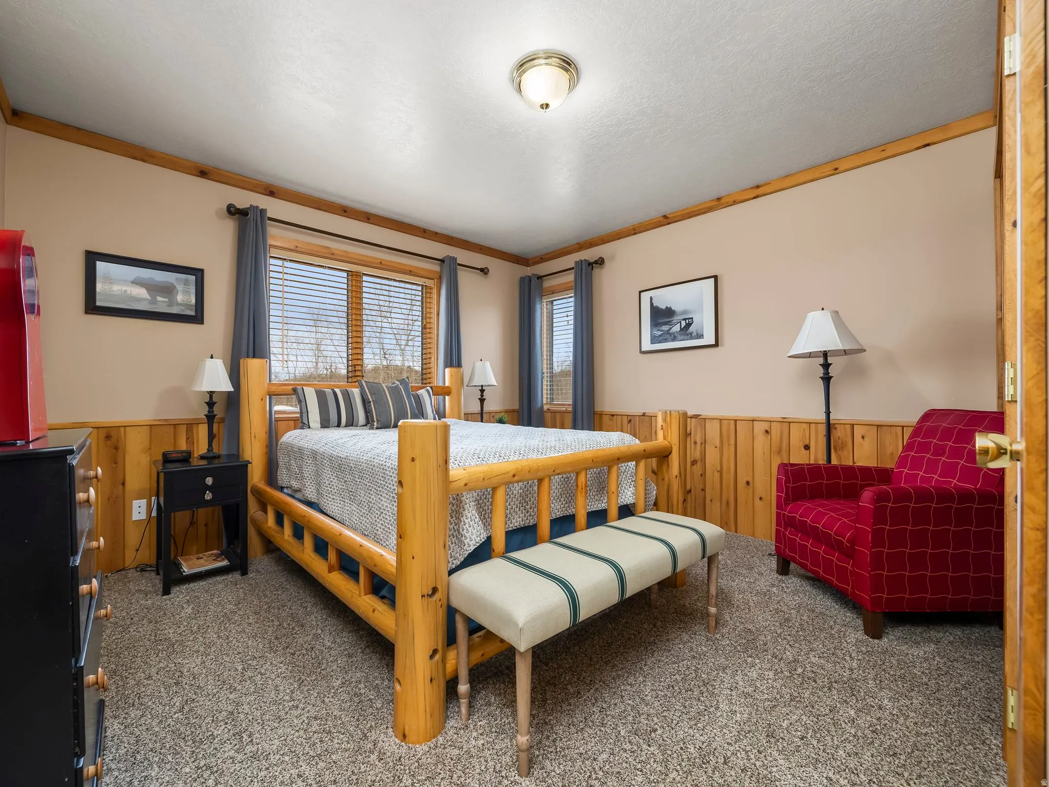 Bedroom featuring wooden walls, wainscoting, and carpet floors