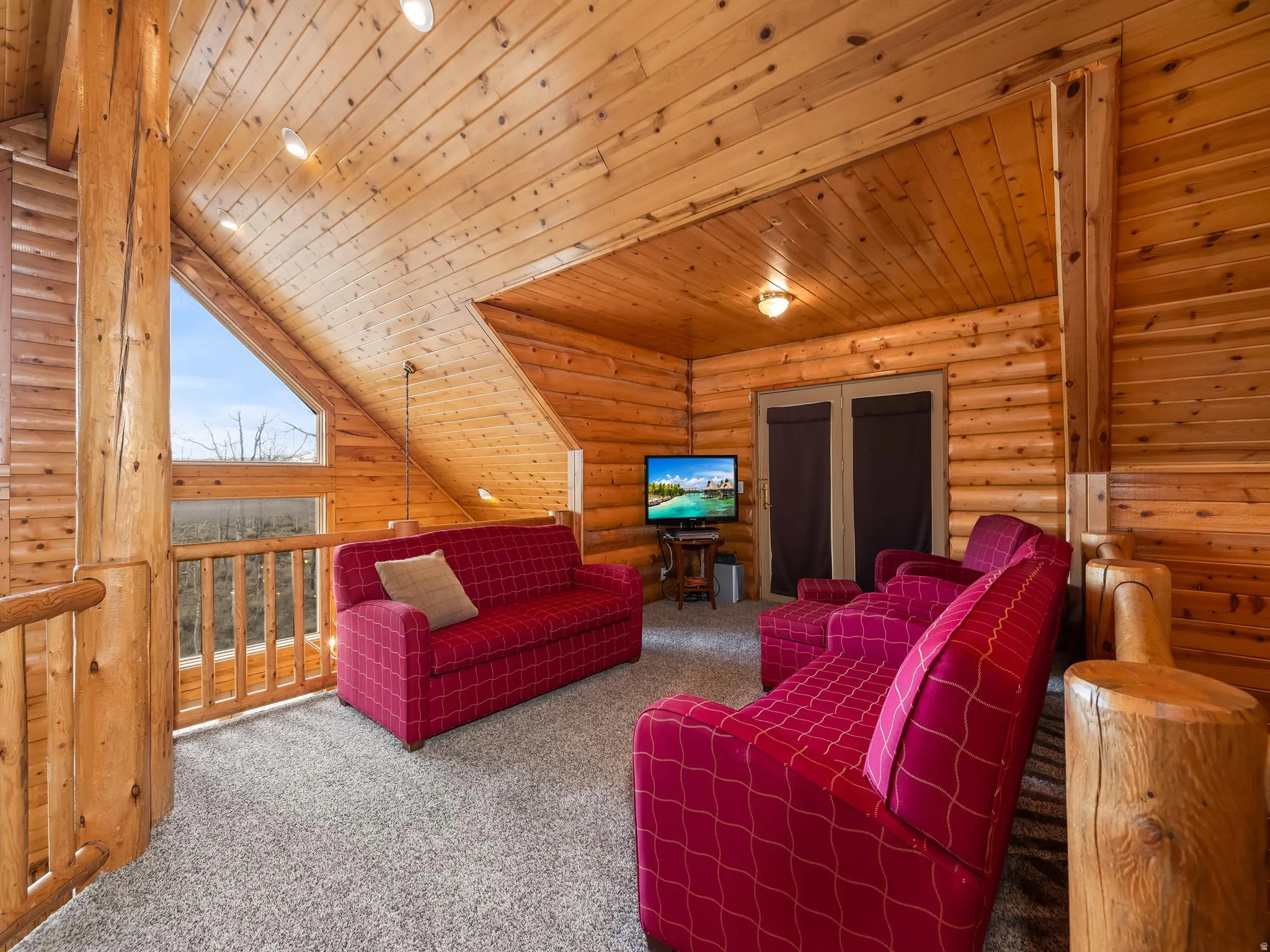 Living area featuring log walls, a vaulted wooden ceiling, carpet floors, and recessed lighting