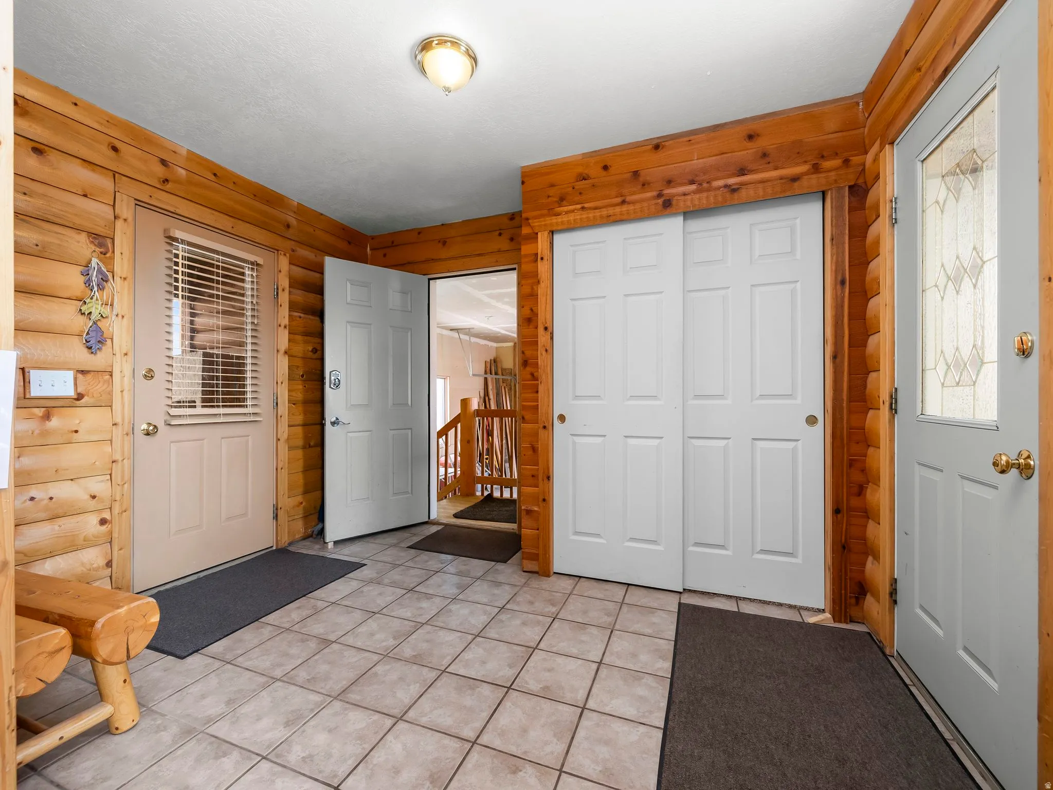 Entryway with rustic walls and light tile patterned floors