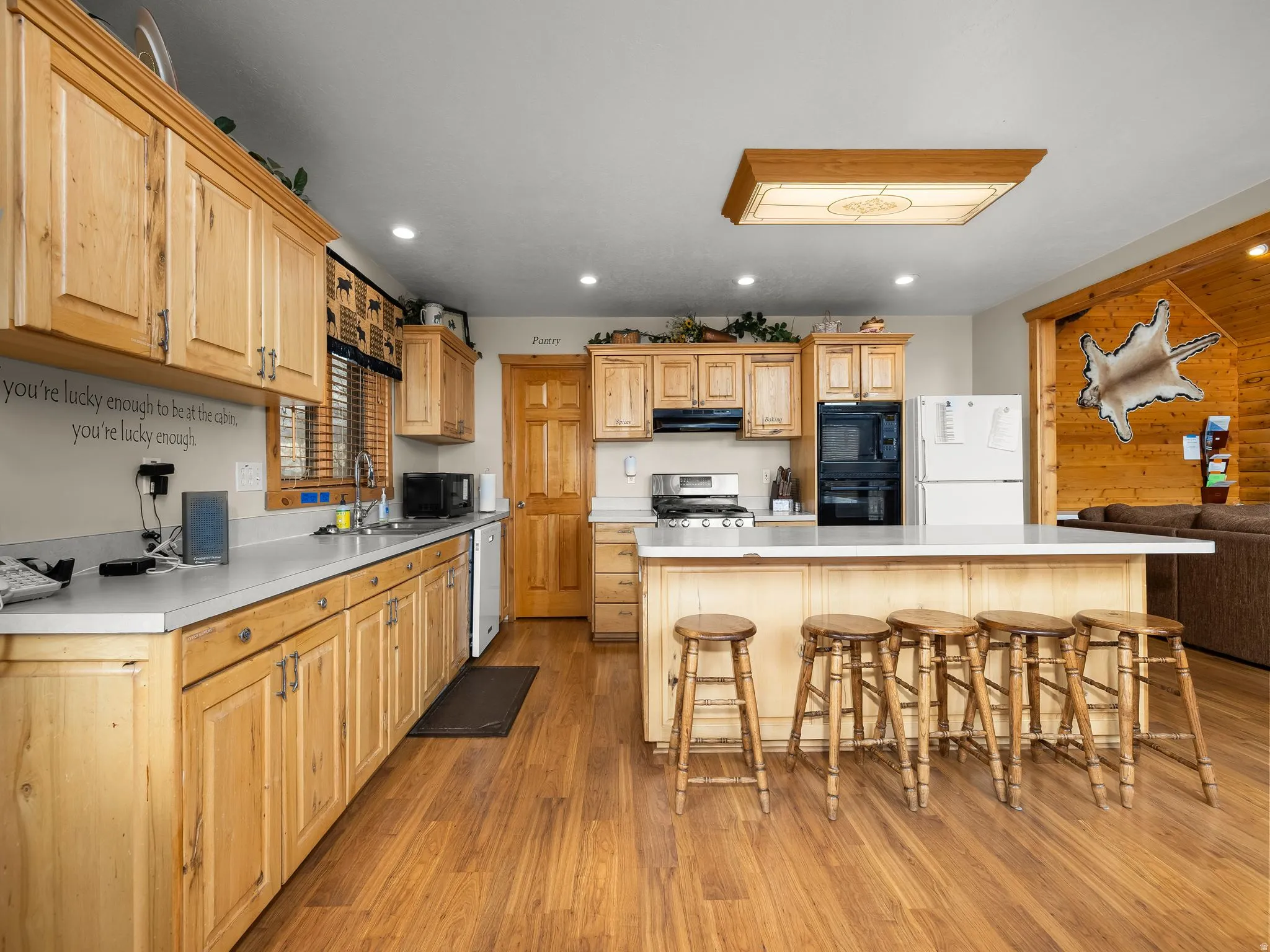 Kitchen with light countertops, a kitchen breakfast bar, light wood finished floors, a kitchen island, and recessed lighting