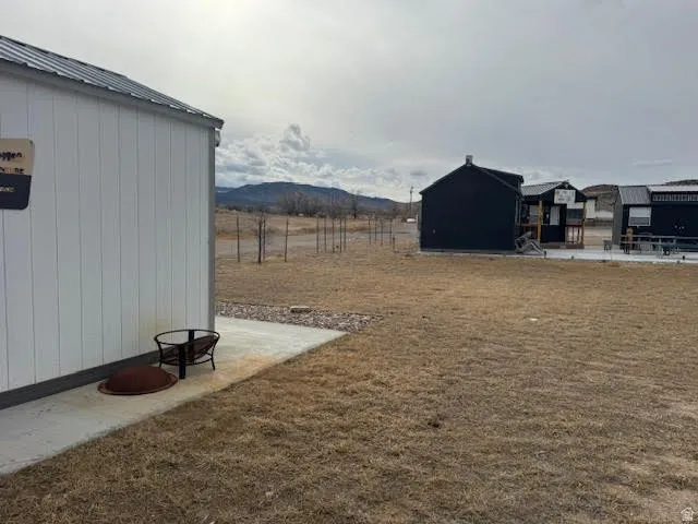 View of grassy yard featuring a patio area and a mountain view