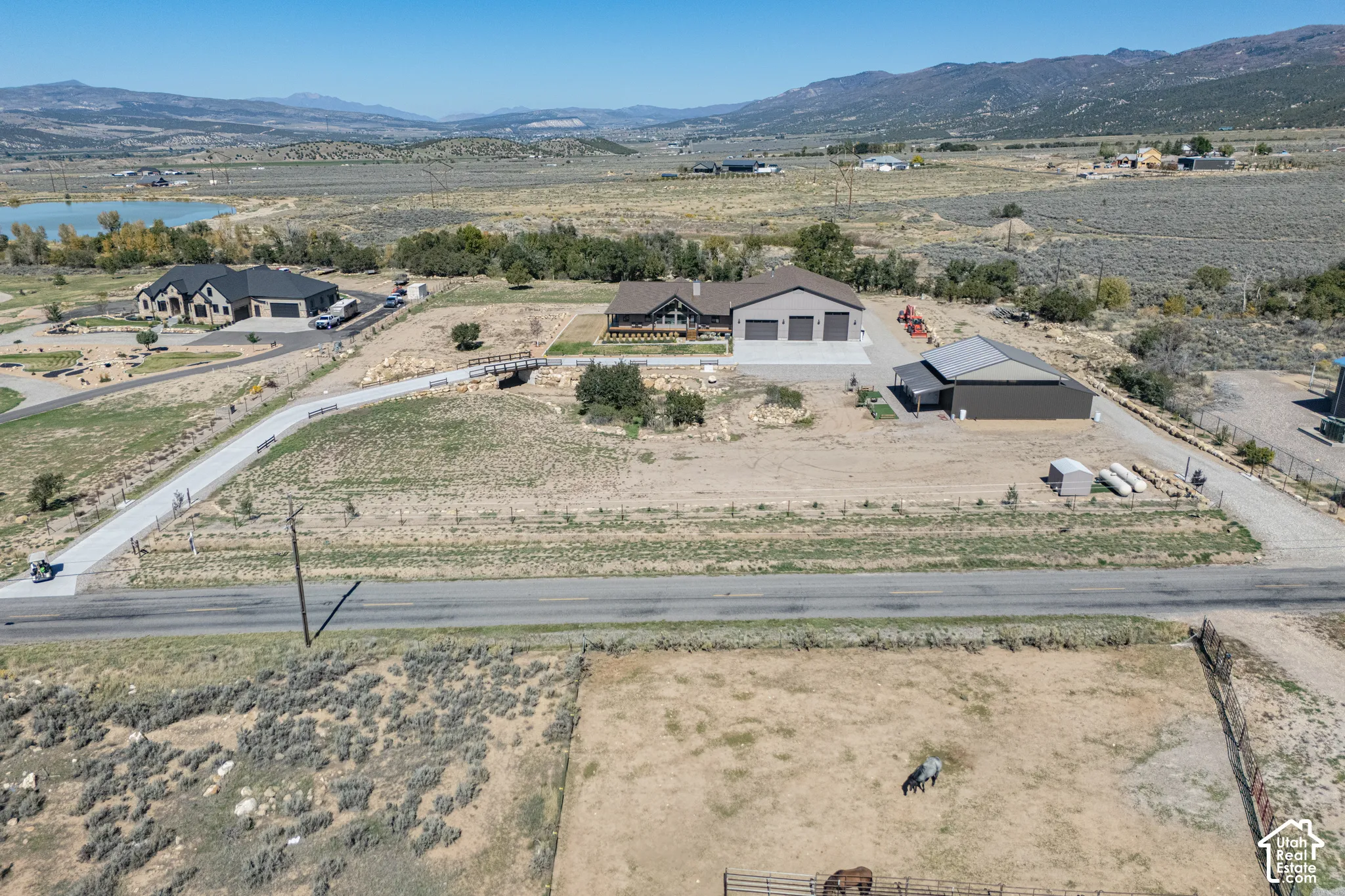 Rural setting with distant mountains, a large outbuilding, and a paved driveway