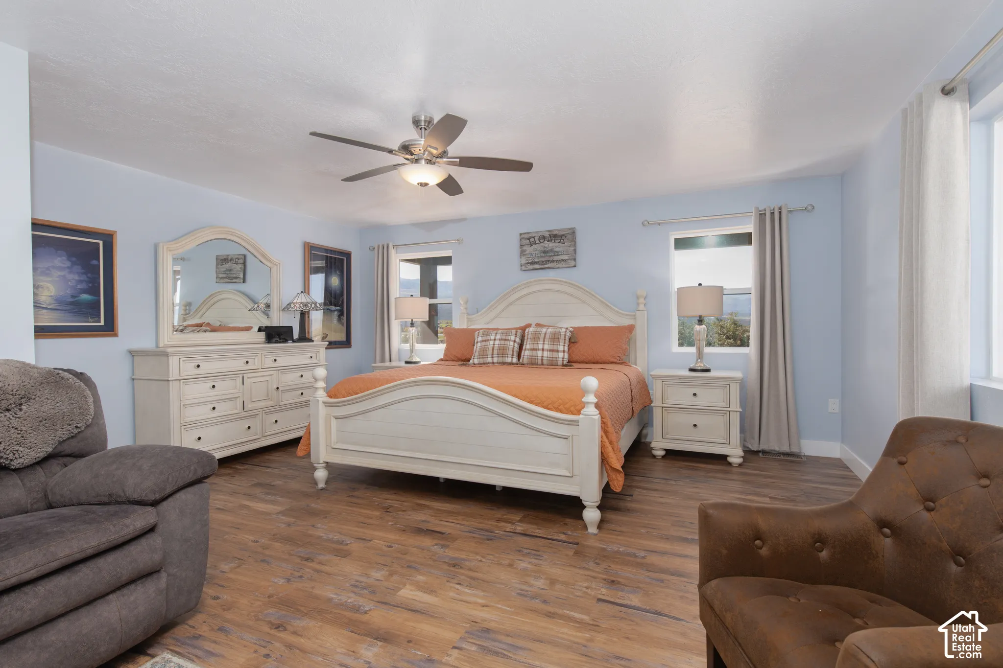 Wood-finish flooring throughout, ceiling fan with integrated lighting, and dual windows