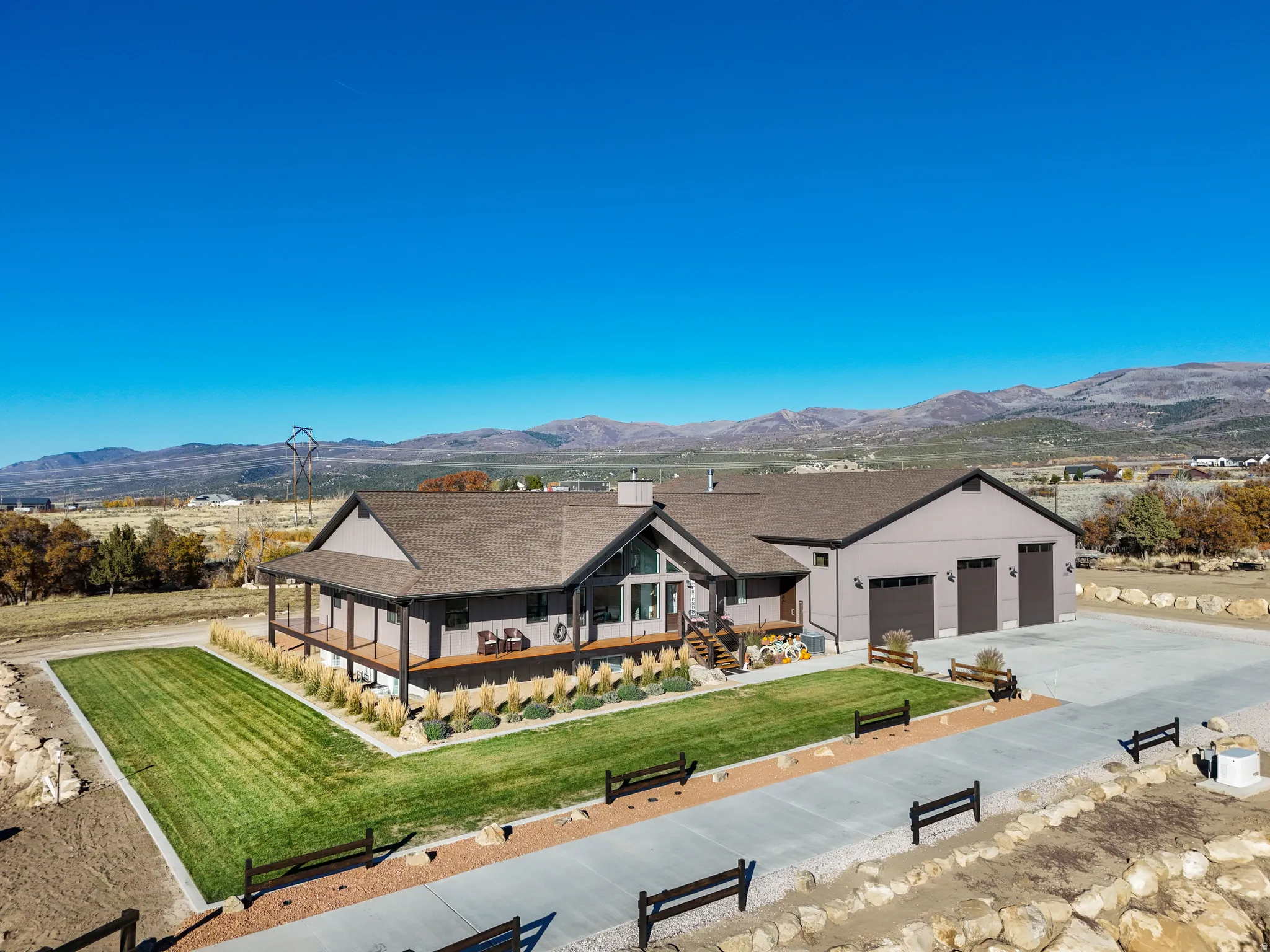 View of front of property with a porch, a mountain view, a front yard, and concrete driveway