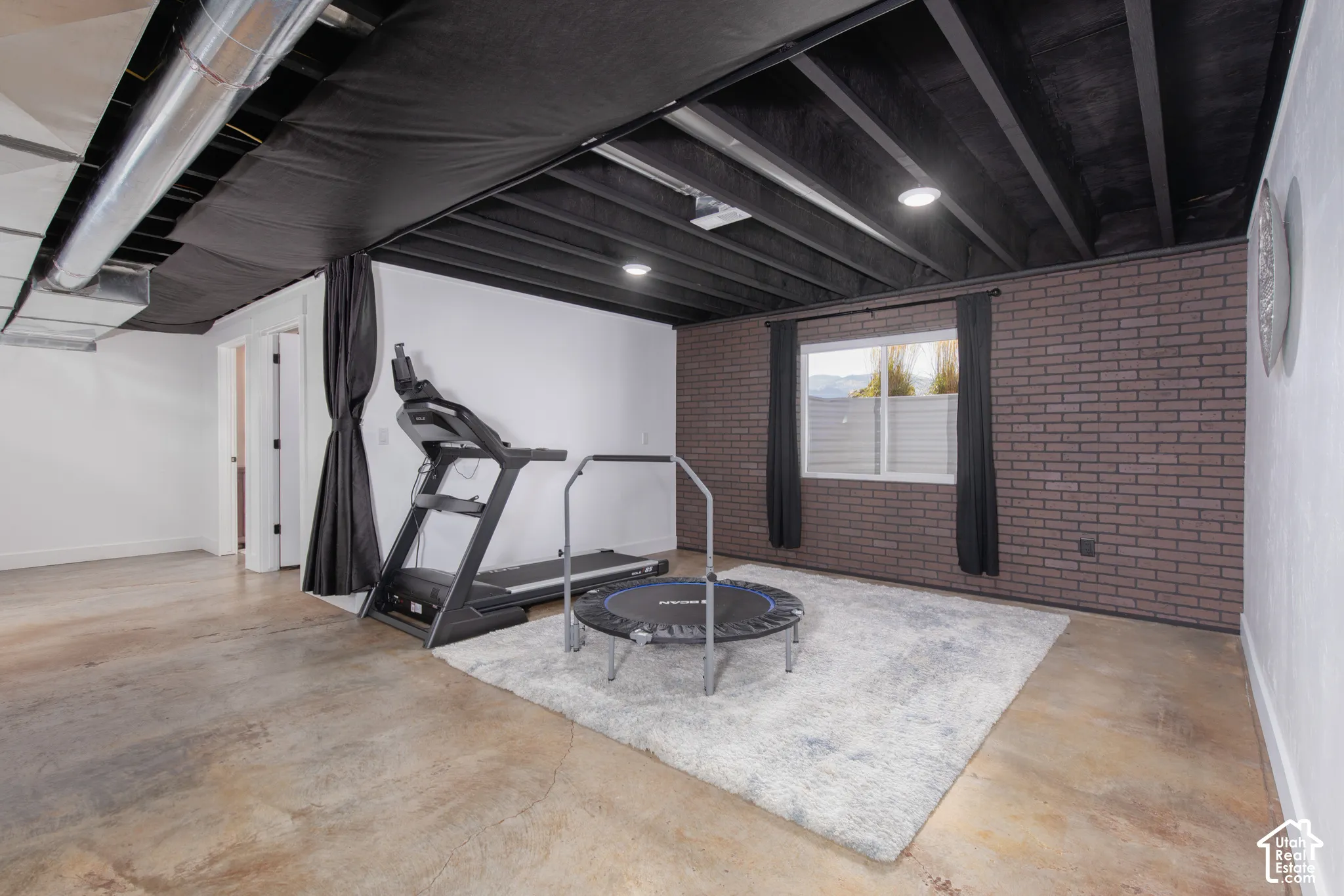 Finished concrete flooring paired with exposed beam ceiling