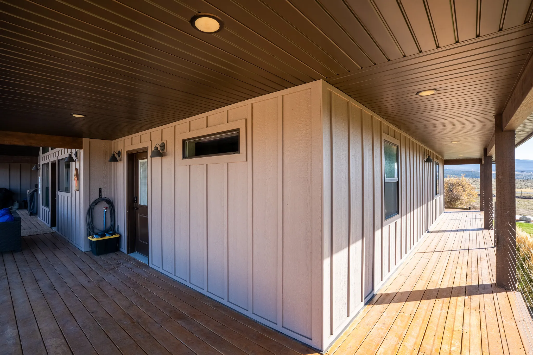 View of heavy timber wrap-around porch from back and side of house