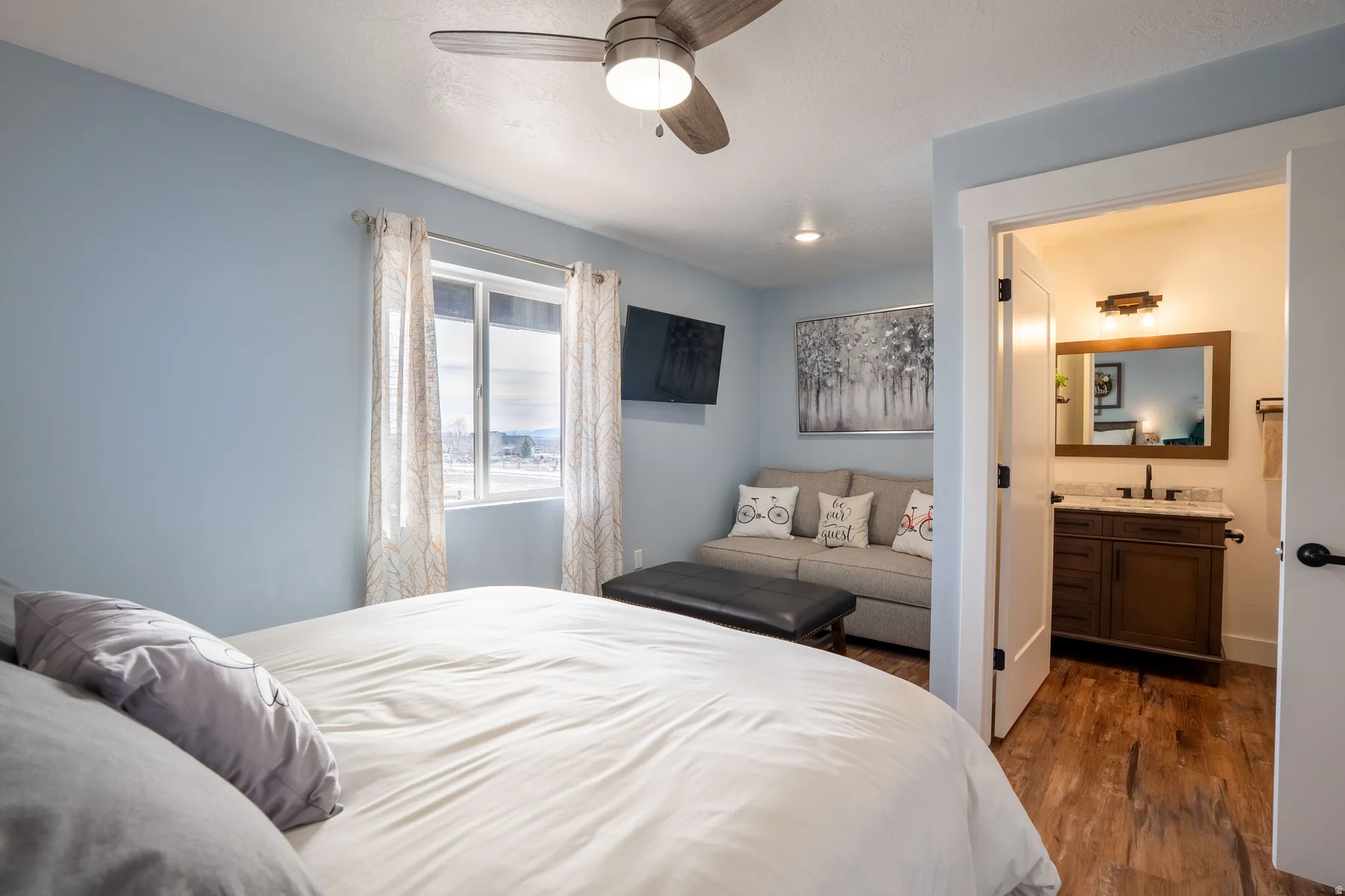 Bedroom 2 with sitting area, ensuite bath, and a ceiling fan