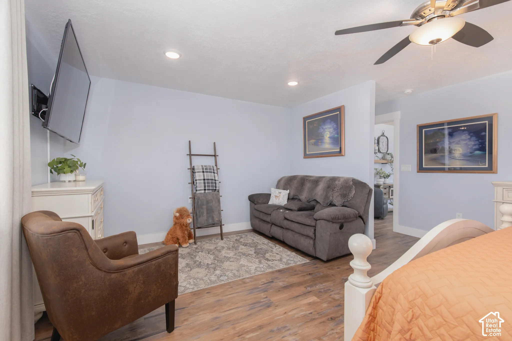 Wood-finish flooring with recessed lighting and a ceiling fan