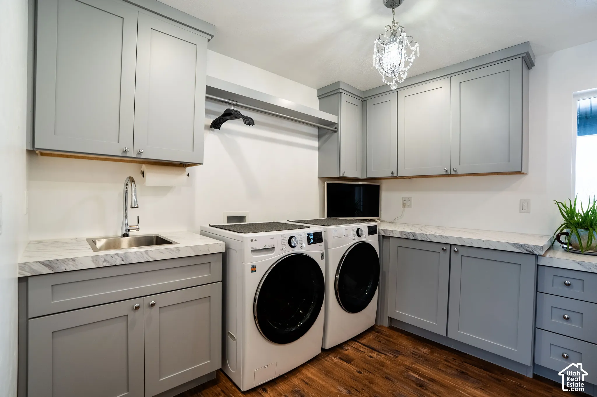 Laundry room with separate washer and dryer, cabinets, sink