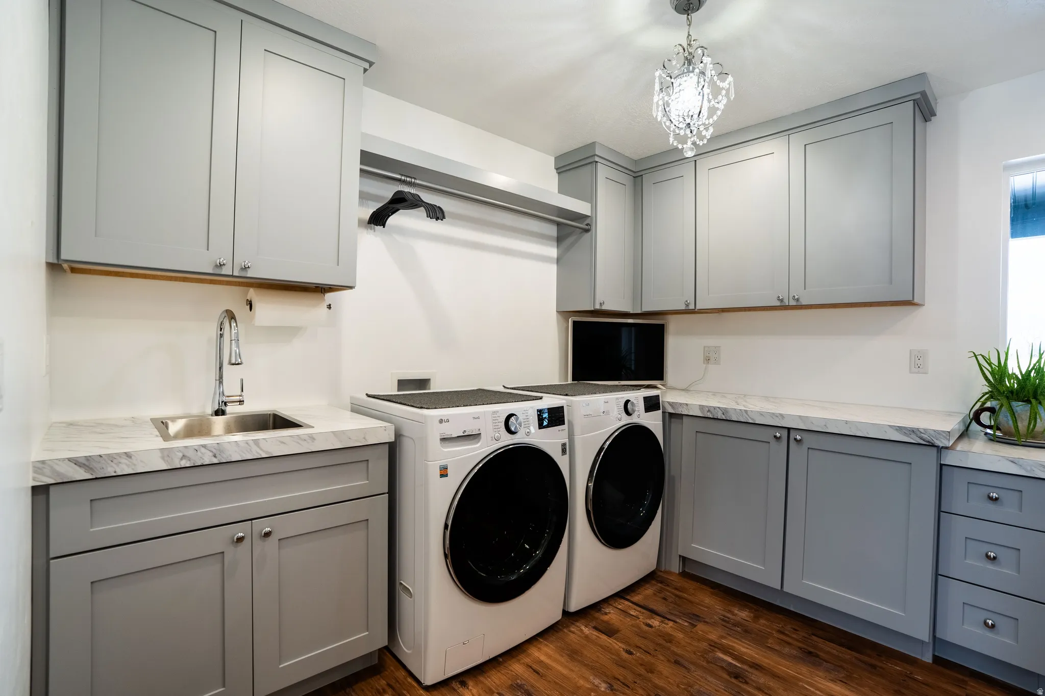 Laundry room with separate washer and dryer, cabinets, sink