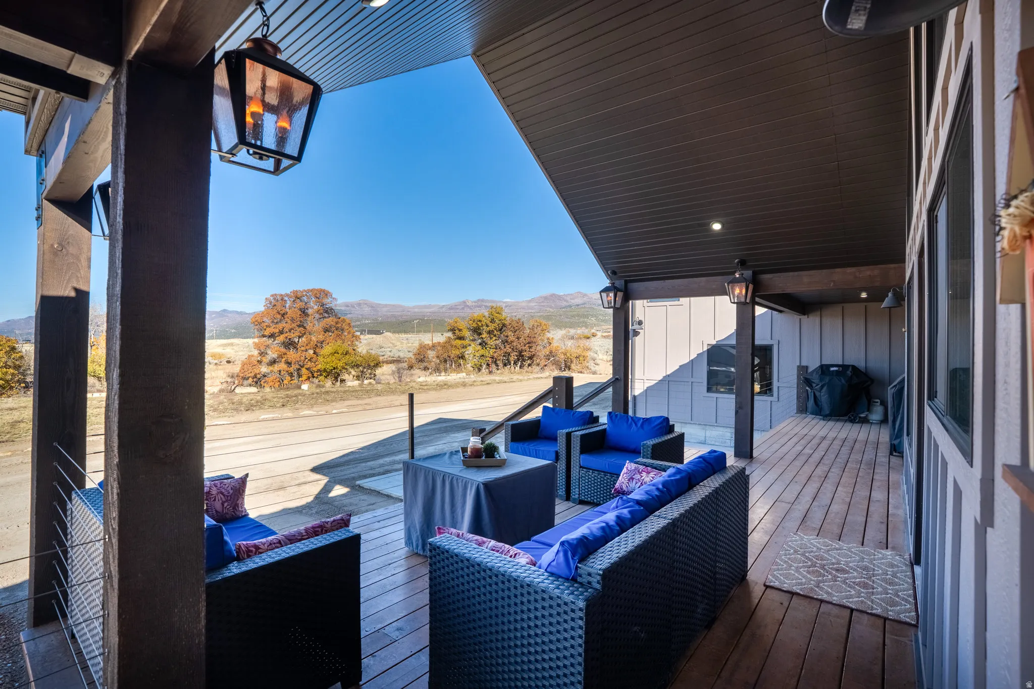 Wooden terrace featuring outdoor seating, a mountain view, and grilling area