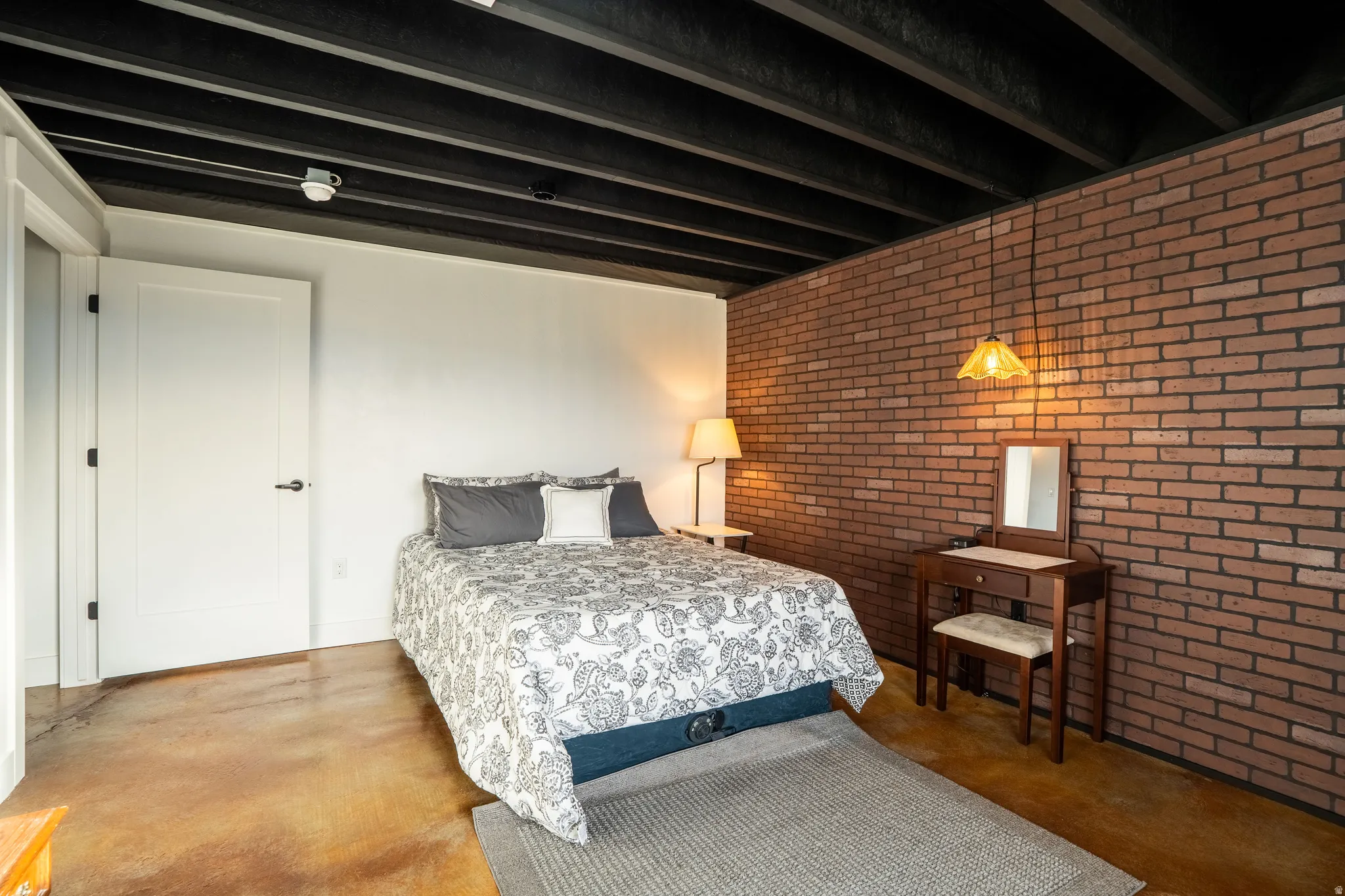 Bedroom 3 with brick wall and concrete floors