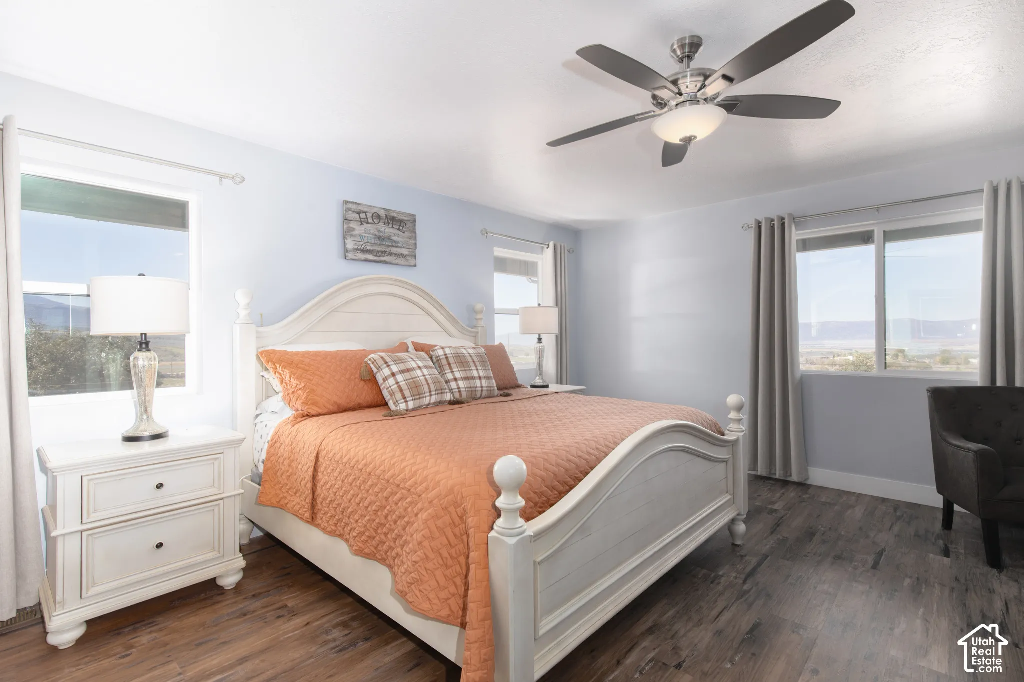 Wood-finish flooring, white walls, and a ceiling fan with integrated lighting