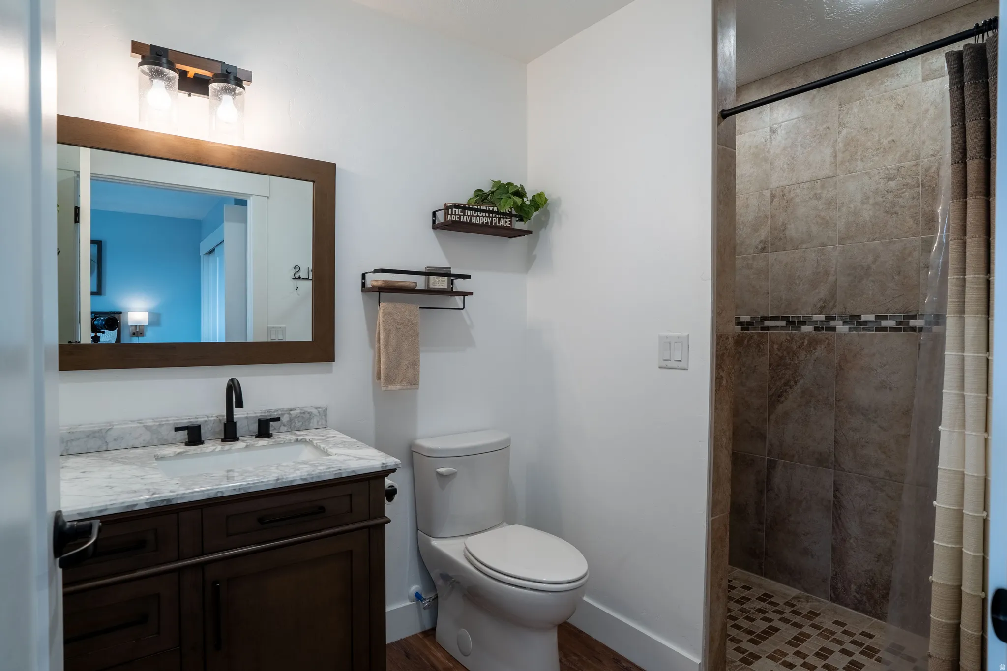 Bedroom 2 with private bathroom, vanity, a shower stall, and dark wood-style flooring