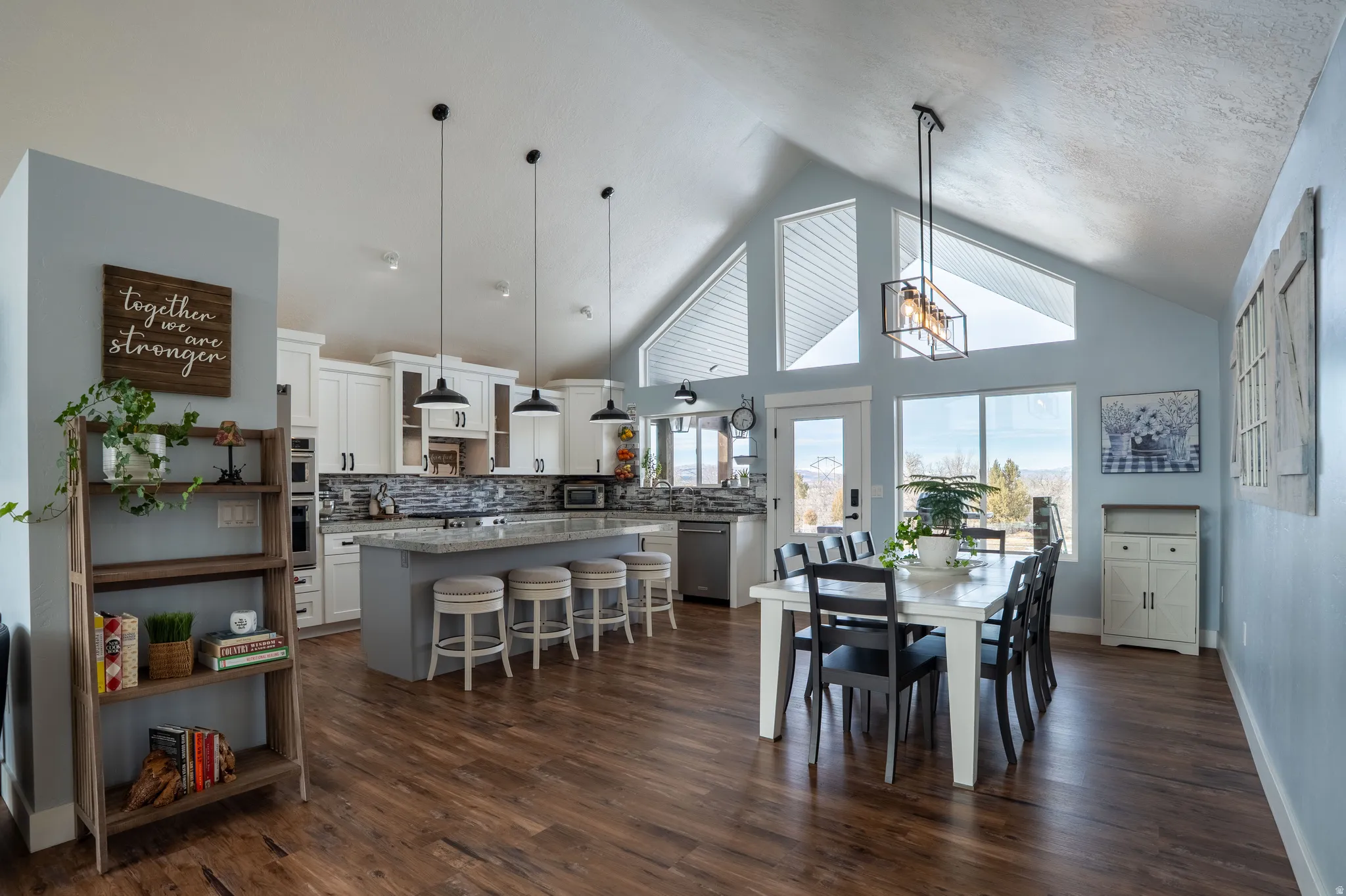 Large kitchen with dining room featuring vaulted ceilings and north view of private backyard