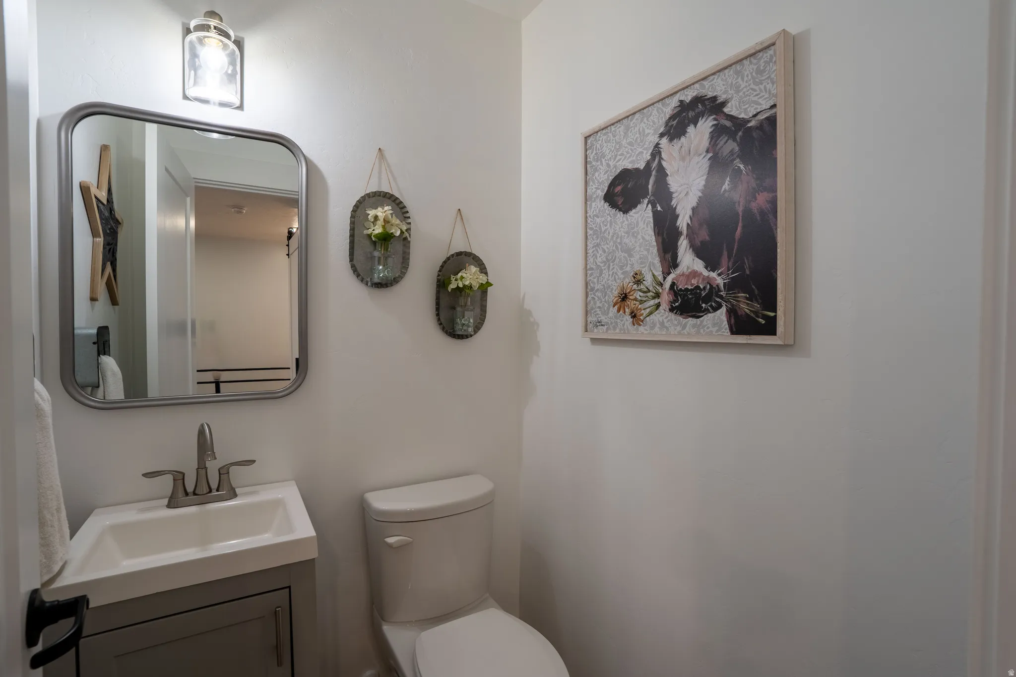 Half bathroom featuring vanity and toilet