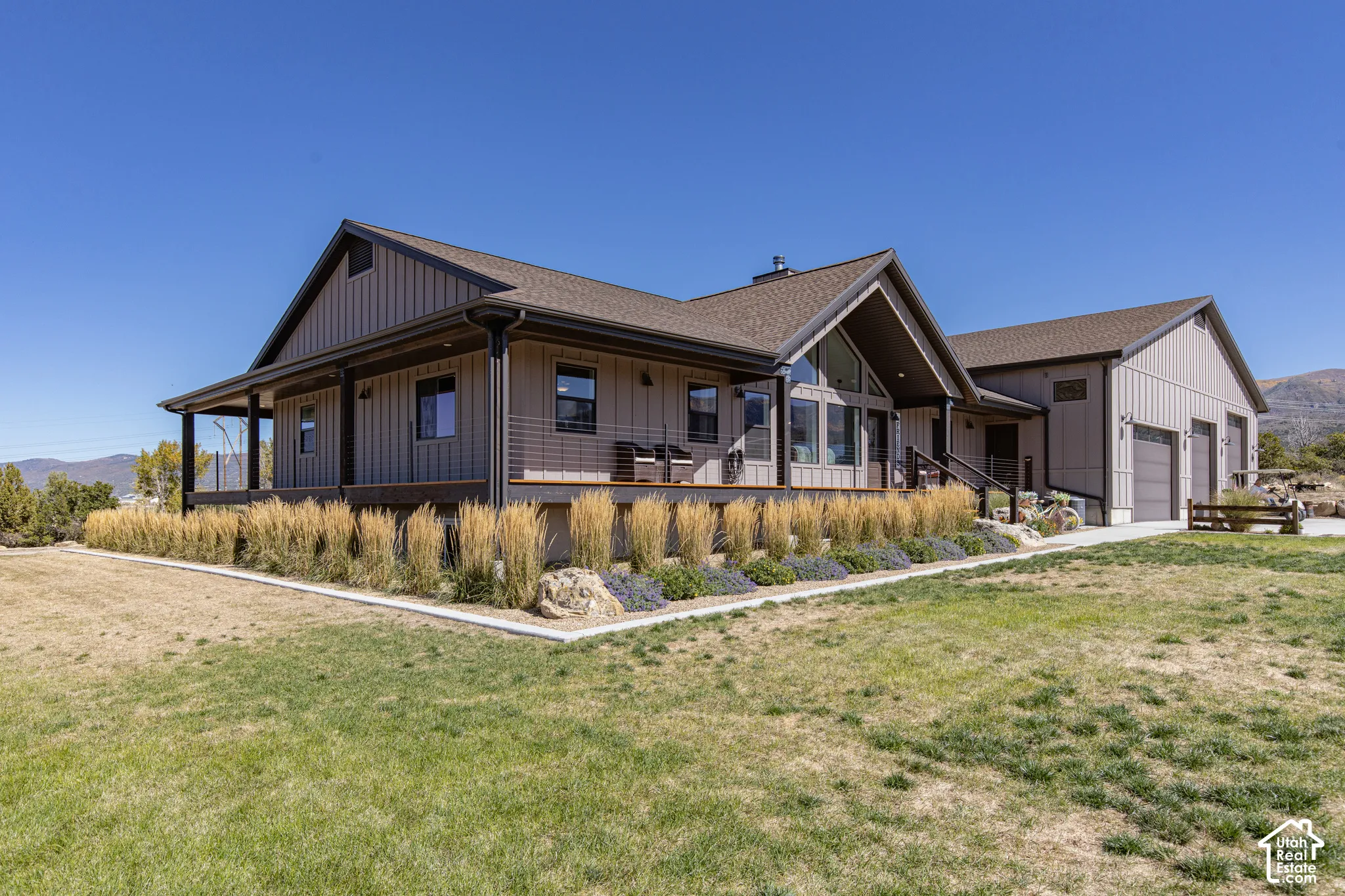 Modern farmhouse exterior with vertical siding, gable roof, covered porch, and an attached three-car garage