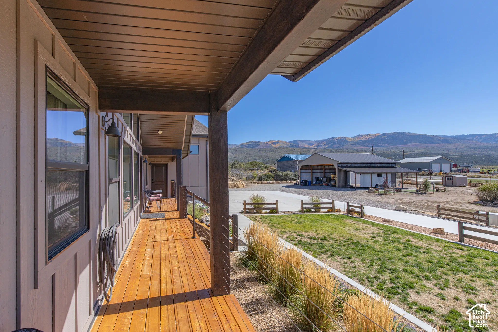 Covered porch with wood-finish flooring, board and batten siding, and dark-framed windows