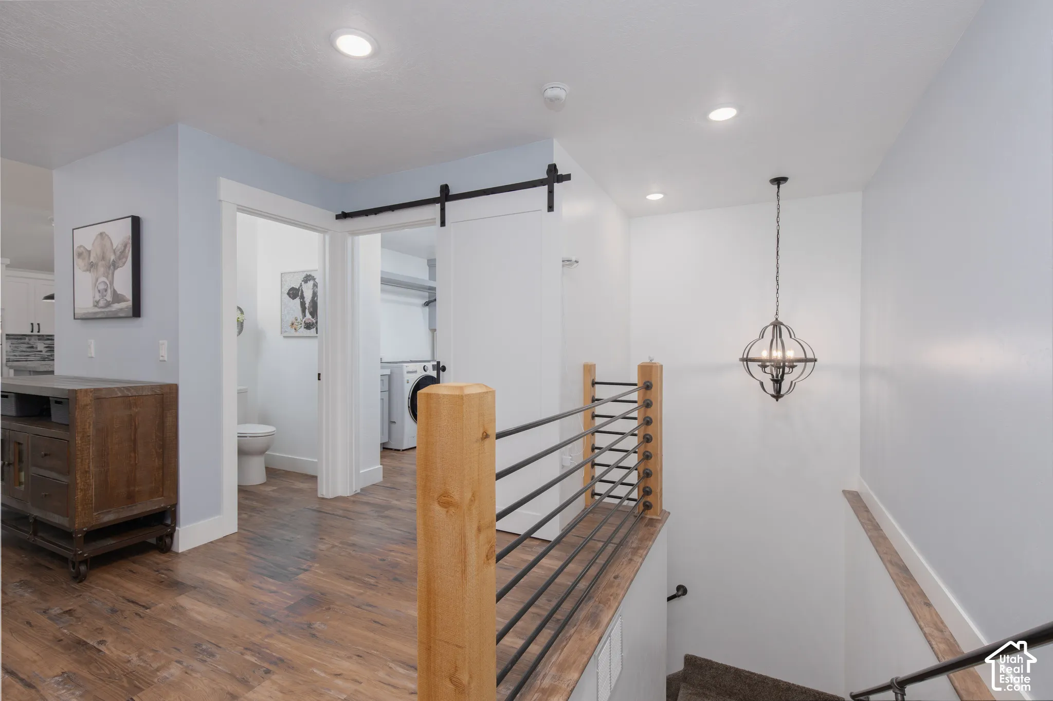 Wood-finish flooring, recessed lighting, and a modern chandelier