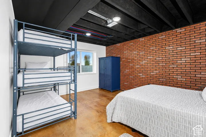 Exposed brick accent wall and concrete flooring
