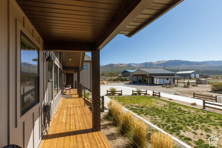 Expansive covered deck with wood-finish flooring, exterior siding, and metal railing