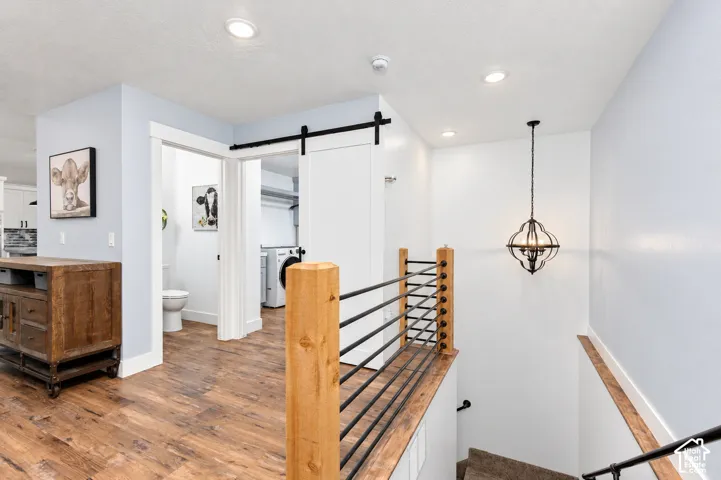 Wood-finish flooring throughout, with a decorative hanging light fixture and recessed ceiling lights