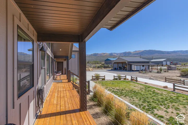 Covered porch with wood-finish flooring, board and batten siding, and dark-framed windows
