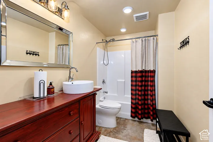 Full bathroom featuring a white vessel sink, a chrome faucet, and a large wall-mounted mirror