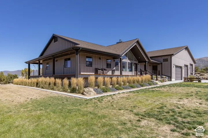 Modern farmhouse exterior with vertical siding, gable roof, covered porch, and an attached three-car garage