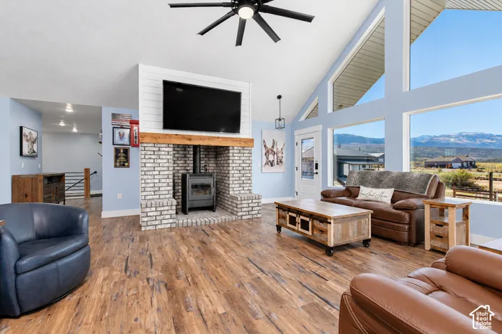 Vaulted ceilings, wood-finish flooring, and a brick fireplace with a wood-burning stove