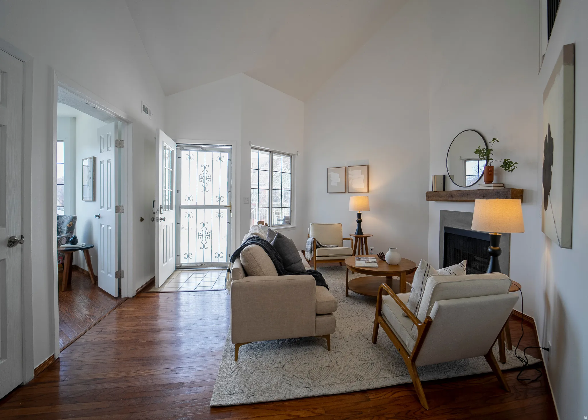 Living room featuring a fireplace, lofted ceiling, and hardwood / wood-style flooring