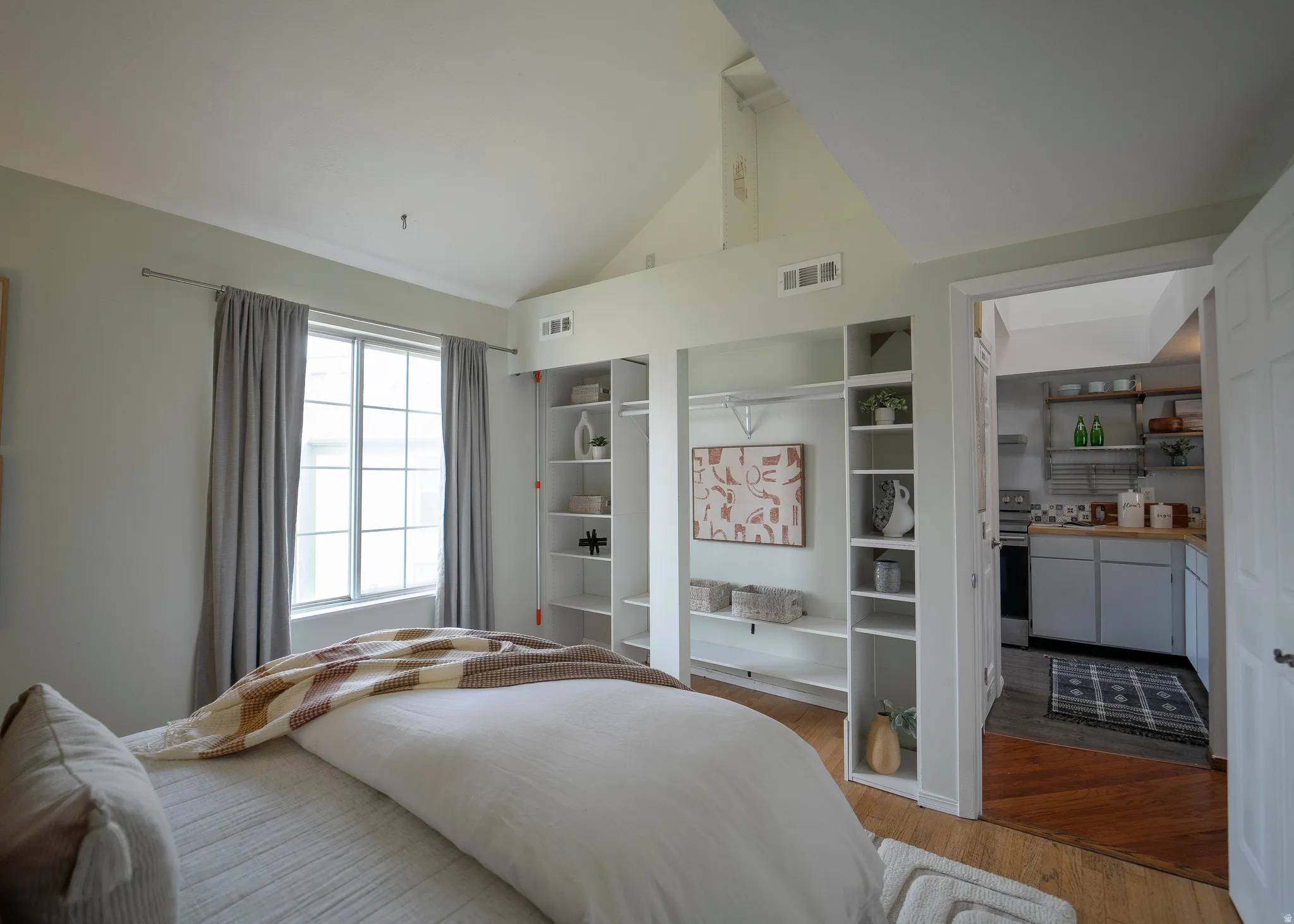 Bedroom with wood finished floors and lofted ceiling