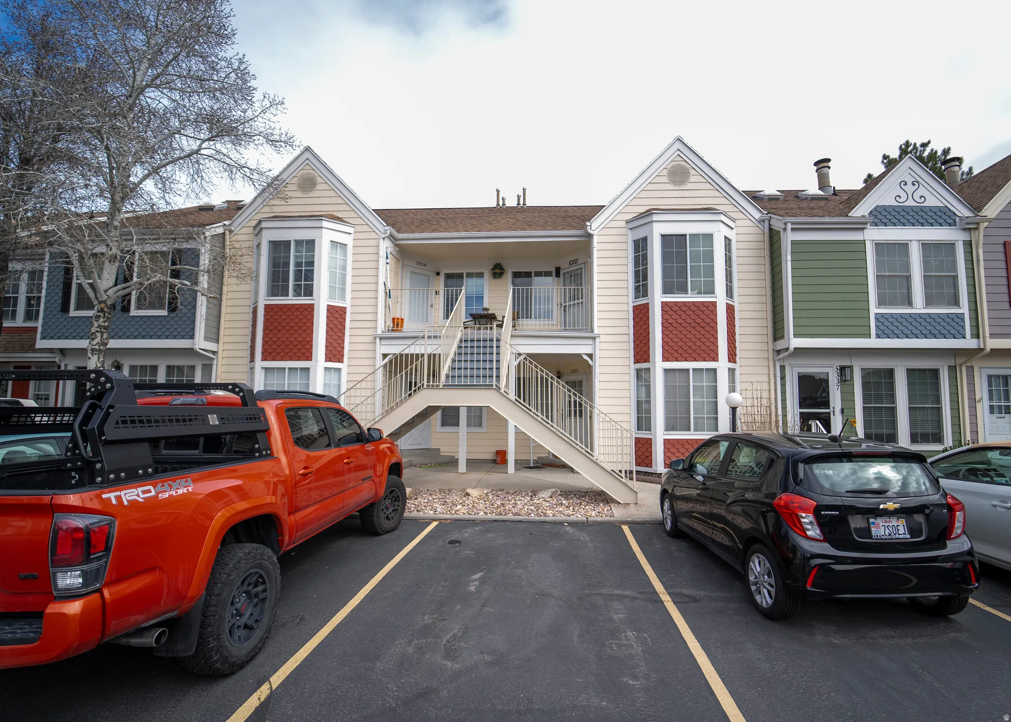 View of building exterior with stairway and uncovered parking